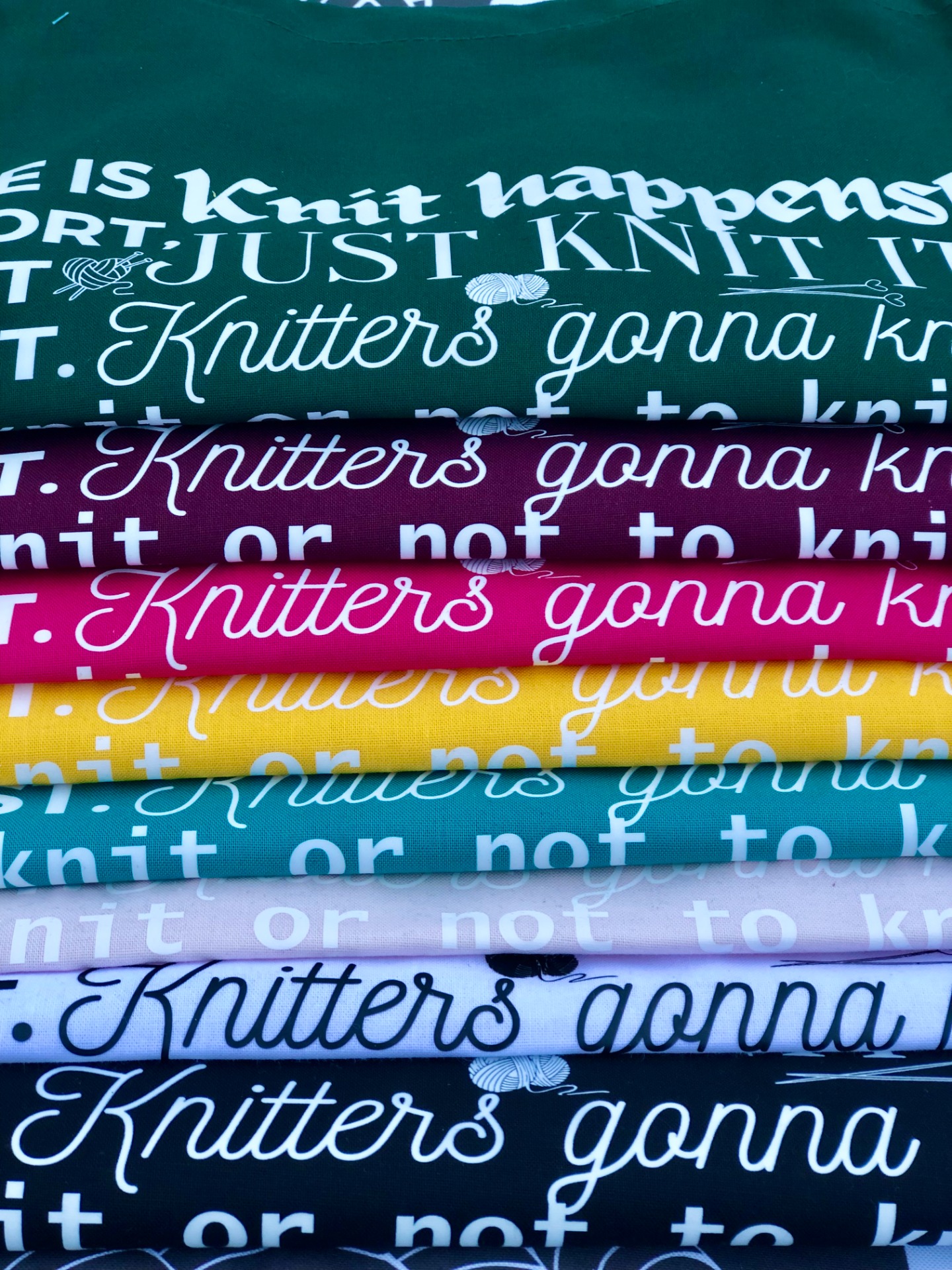 Knit happens-puuvillakassin värit ylhäältä alas: pullonvihreä, viininpunainen, pinkki, keltainen, turkoosi, haalea vaaleanpunainen, valkoinen ja musta